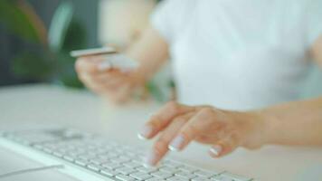 mujer mecanografía crédito tarjeta número en computadora teclado. ella haciendo en línea compra. en línea pago Servicio video