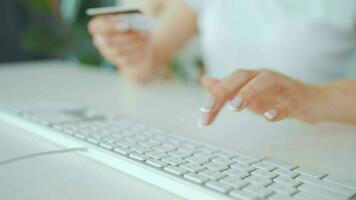 Woman typing credit card number on computer keyboard. She making online purchase. Online payment service video