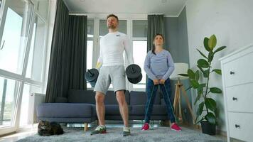 Caucasian couple doing strength training at home in cozy bright room video