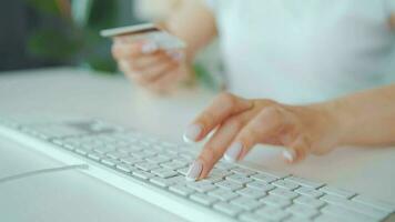 mujer mecanografía crédito tarjeta número en computadora teclado. ella haciendo en línea compra. en línea pago Servicio video