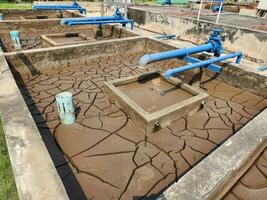 seco y agrietado suelo o sedimento de el tratamiento estanque foto