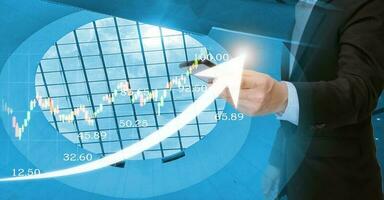 On a virtual interface goal chart, a businessman uses a tablet to analyze growth graph financial data and sales profit. As a result of intelligent technology, smart business solutions are developed. photo