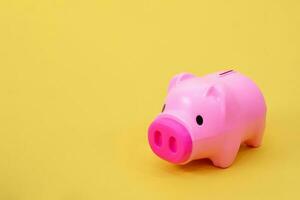 Piggy bank money coins on a yellow background photo