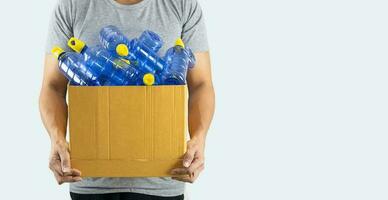 A man carrying a box with a plastic bottle to be recycled photo