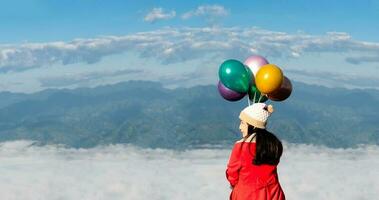 woman holding colorful balloons travel mountains and fog photo