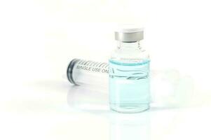 antivirulento vacuna botella y médico jeringuilla en un blanco antecedentes foto
