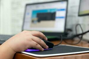 Children enjoying computer games while holding a computer mouse photo