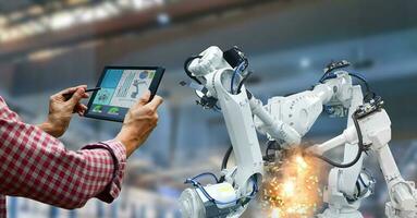 Industrial robot operator in factory holding tablet photo