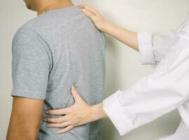 The doctor examines a patient with back pain Inflammation of the back photo