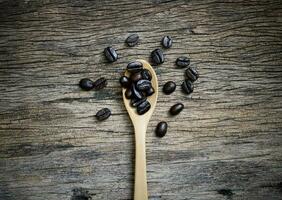 Coffee cup and coffee beans roasted in a sack on a wooden floor. photo