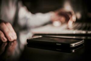 Cellphone on the Glassy Desk photo