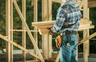 Construction Worker Moving Wood Material photo