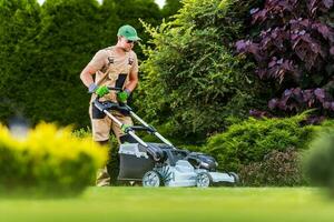 Gardener Performing Lawn Maintenance Using Power Mower photo