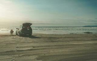 Woman Enjoying Beach Place Seating Alone Next to Her Car photo