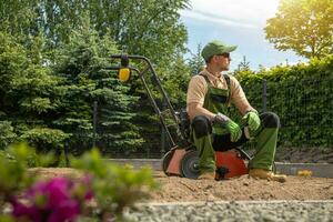 Gardener Relaxing After Backyard Lawn Aeration photo