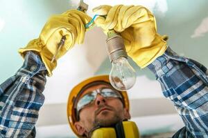 Electrician Checking Cables in a Lighting System to Fix a Bug photo