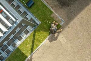 Landscaping Worker Installing New Natural Grass Turfs in a Backyards Garden photo
