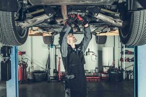 Mechanic Fixing Car on a Lift photo