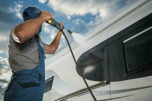 Caucasian Men Pressure Washing His Modern Camper Van RV photo