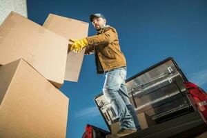 Mover Packing Client's Boxes in the Trunk of His Car photo