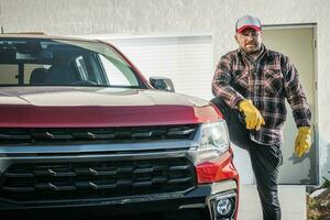 Proud Mechanic Standing Next to Pickup Truck photo