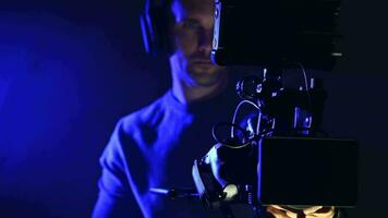 Caucasian Digital Film Camera Operator in Dark Blue Illuminated Place video