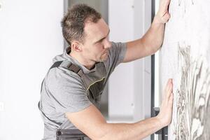 Caucasian Men Installing Wallpaper on His Bedroom's Wall photo