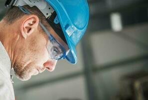 construcción trabajador en difícil sombrero y ojos la seguridad lentes foto