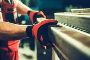 Metalworking Shop Worker Taking Piece of a Metal Square Tube photo