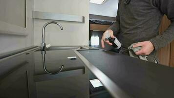 Caucasian Man Cleaning RV Kitchen Area Table Using Soft Cloth and Detergent Inside His Camper Van video