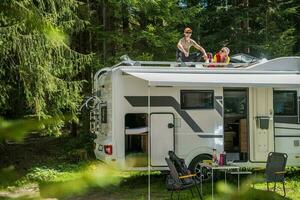 Happy Family Relaxing on the Roof of Their RV photo