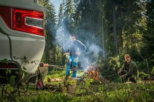 Friends Hanging Out Next to Campfire and RV Camper Van photo