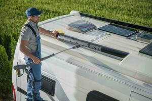 Smiling Caucasian Men Washing His Motorhome RV Camper Van photo