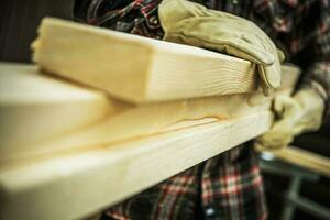 Construction Worker Moving Wood Beams Close Up photo