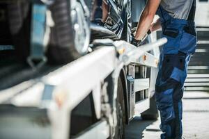 Worker Securing Car on a Towing Truck photo