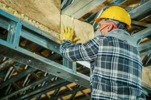 Construction Worker Insulating Building Ceiling photo