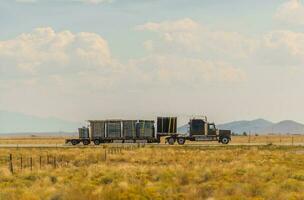 Semi Truck on a Highway Crossing Colorado Valley photo