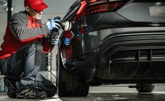 Car Detailing Worker Removing Water From a Car Body Using Soft Cloth photo