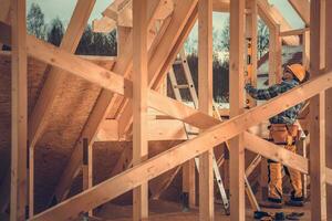 Construction Contractor Supervisor Performing Final Levels Check on Wooden Skeleton Frame photo