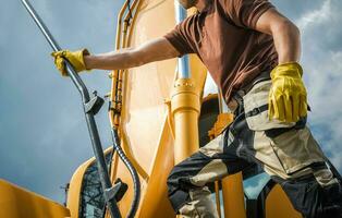 profesional excavador operador consiguiendo Listo para un trabajo foto