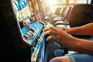 Gambler Playing Slot Machine Inside a Casino photo