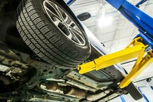 Broken Car on an Automotive Lift Inside Auto Service Center photo