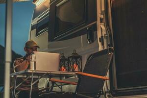 Self Employed Men Doing His Online Job Next to Camper Van photo