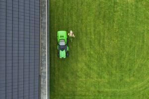 Aerial View of Riding Lawn Mower and Caucasian Gardener. photo