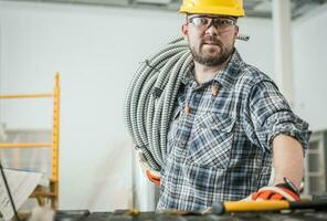 Electrician Contractor Worker with Metal Electric Conduit photo