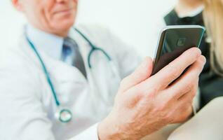 Medical Doctor Looking at His Smartphone Device photo