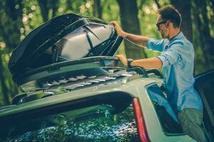 hombres apertura coche techo estante en bosque foto