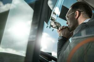 Pensive Bus Coach Driver Behind Vehicle Wheel photo