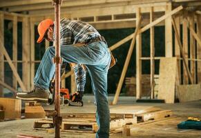 Construction Contractor with Chainsaw Preparing Wood Elements photo