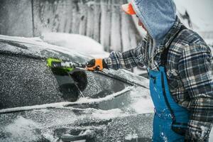 Men Removing Fresh Snow From His Car photo